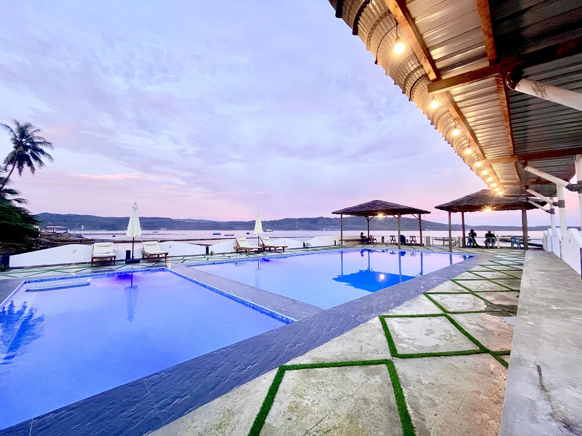 Swimming pool at Raffiel Nias at dusk, overlooking the ocean at Sorake Beach